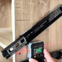Inclinómetro digital midiendo un ángulo con láser sobre una superficie de madera