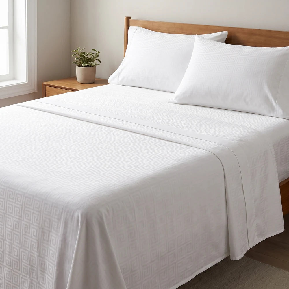 Cama tendida con el juego de sábanas blanco de 600 hilos, luz de mañana