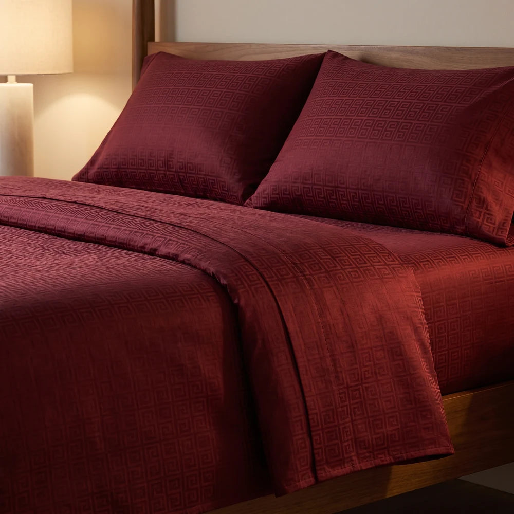 Sobresábana doblada sobre la cama en vino tinto