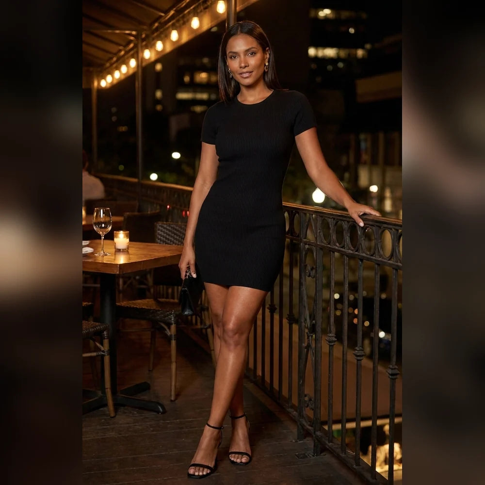 Vestido rib negro con tacones en la terraza de un restaurante de noche